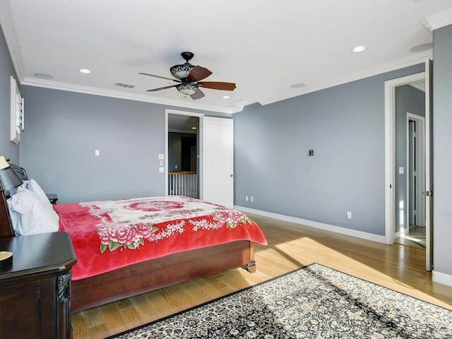 bedroom with ceiling fan, crown molding, and hardwood / wood-style floors