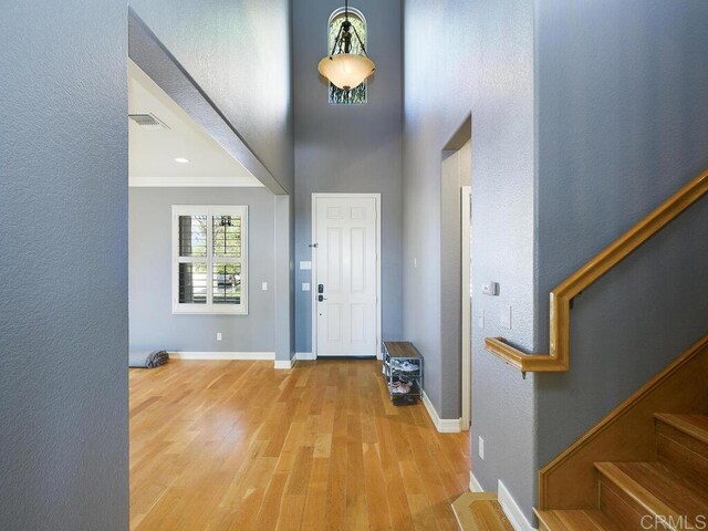 foyer featuring ornamental molding and hardwood / wood-style floors