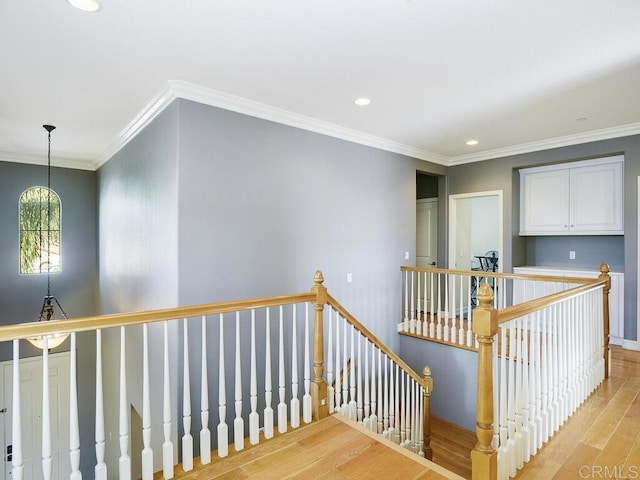 staircase with a chandelier, crown molding, and hardwood / wood-style floors