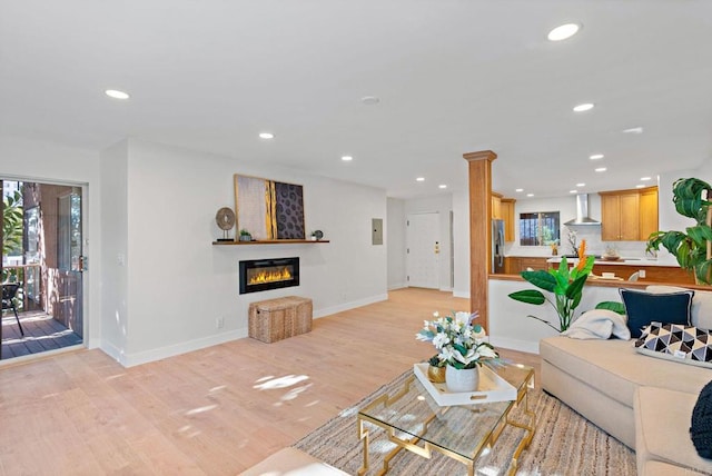 living room featuring decorative columns and light hardwood / wood-style flooring