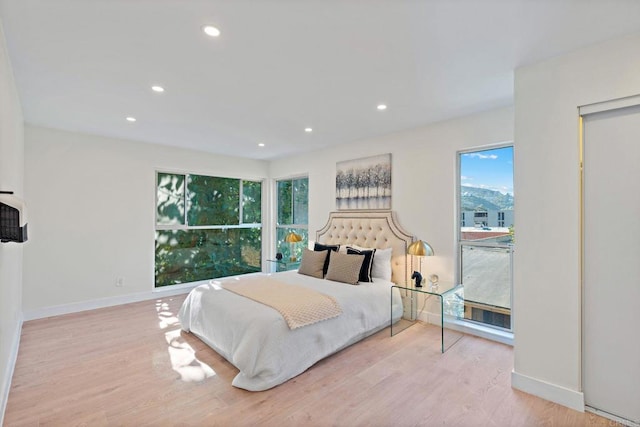 bedroom with light hardwood / wood-style flooring and multiple windows