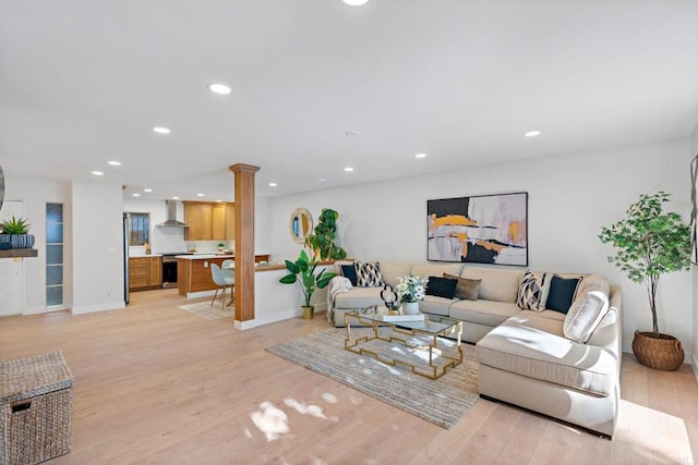 living room with decorative columns and light wood-type flooring