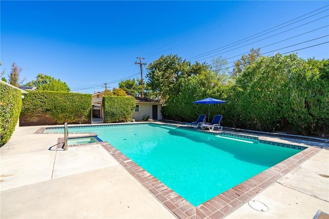 view of swimming pool featuring a patio area and a pool with connected hot tub