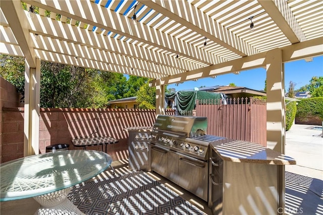 view of patio / terrace featuring a fenced backyard, a pergola, outdoor dining area, and exterior kitchen