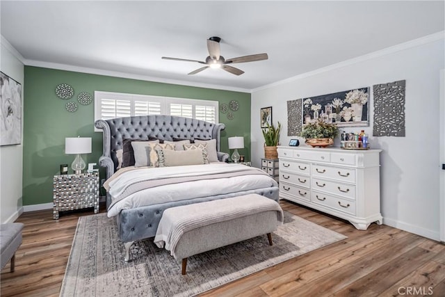 bedroom with baseboards, ornamental molding, a ceiling fan, and wood finished floors
