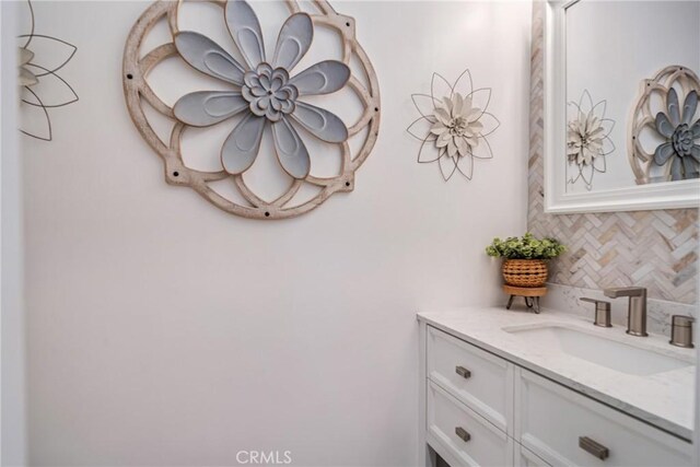 bathroom featuring vanity and decorative backsplash