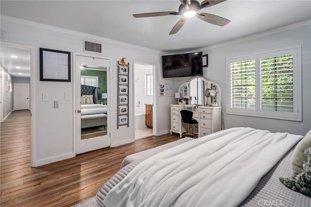 bedroom with ceiling fan, hardwood / wood-style floors, ornamental molding, and ensuite bath