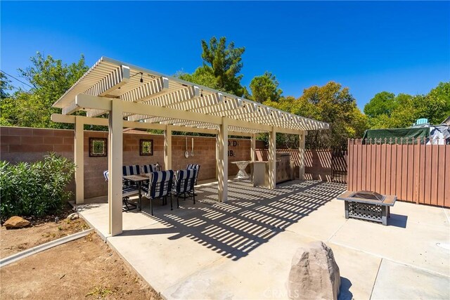 view of patio / terrace featuring a fire pit, fence, and a pergola