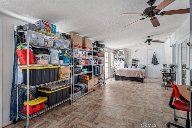 storage area with ceiling fan and french doors