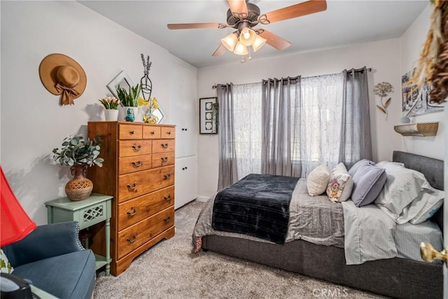 bedroom with ceiling fan and light carpet