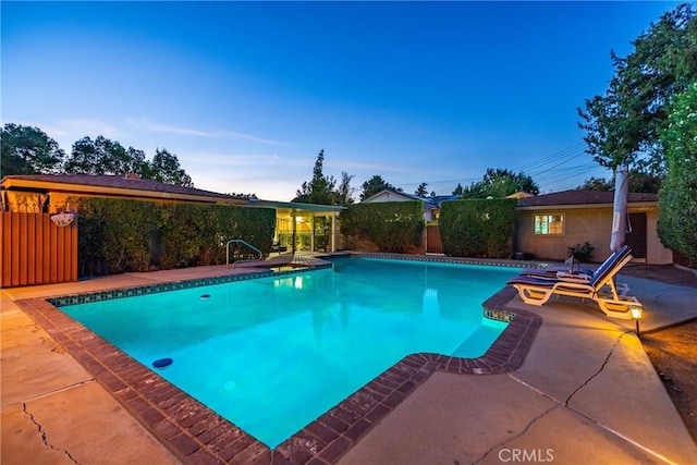 pool at dusk with a patio area