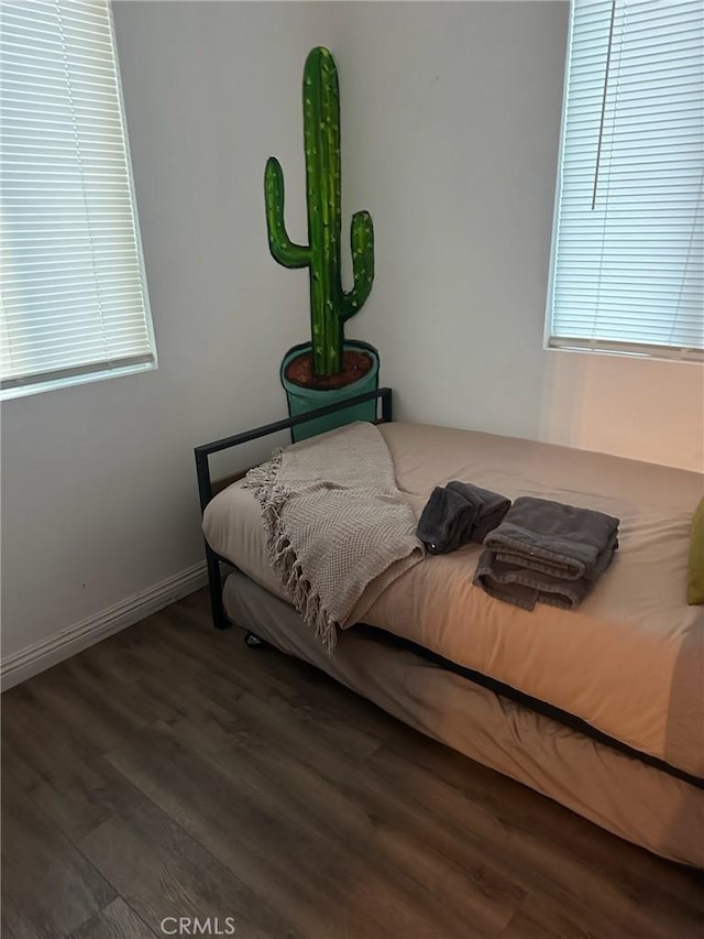 bedroom featuring wood finished floors and baseboards