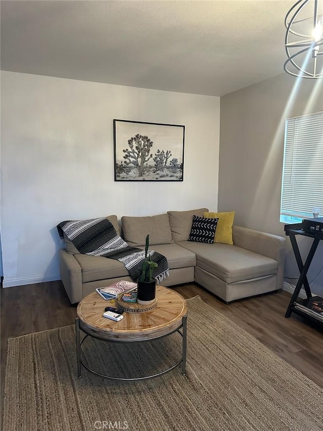 living room featuring dark wood-type flooring and a chandelier