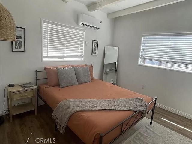 bedroom with a wall unit AC, wood finished floors, beam ceiling, and baseboards