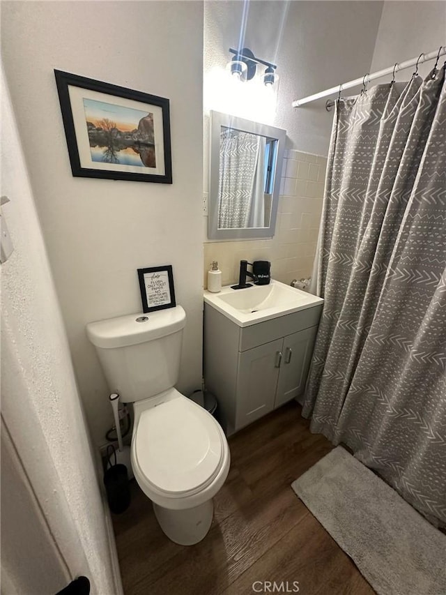 bathroom featuring hardwood / wood-style flooring, toilet, vanity, and a shower with curtain