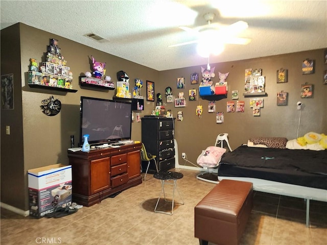 living room with ceiling fan, light tile patterned floors, and a textured ceiling