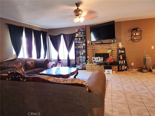 tiled living room with ceiling fan, a textured ceiling, and a fireplace