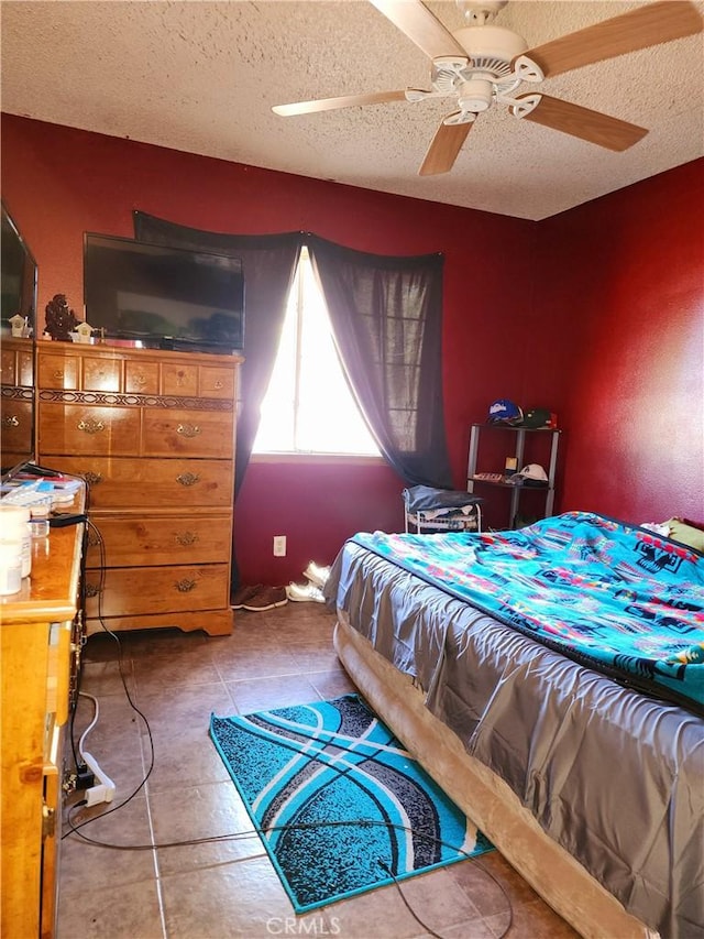 bedroom with ceiling fan, a textured ceiling, and light tile patterned floors