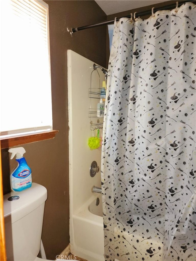 bathroom featuring washtub / shower combination and toilet