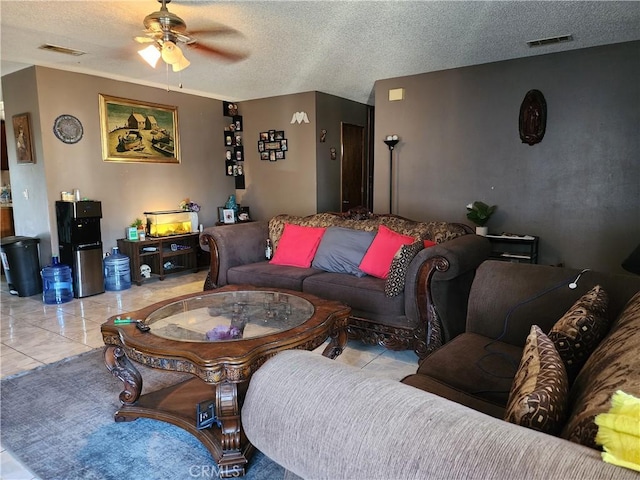 tiled living room with ceiling fan and a textured ceiling