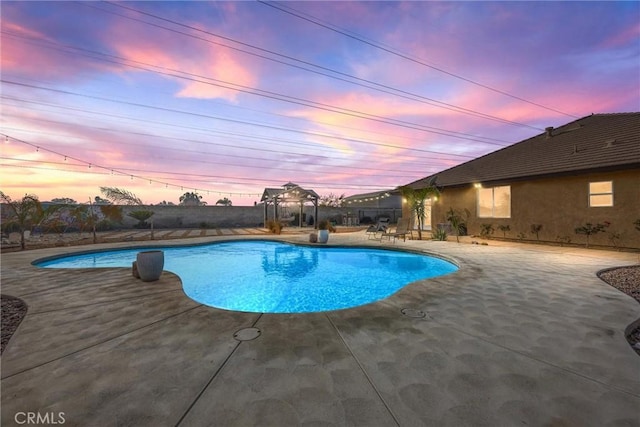 pool at dusk with a patio