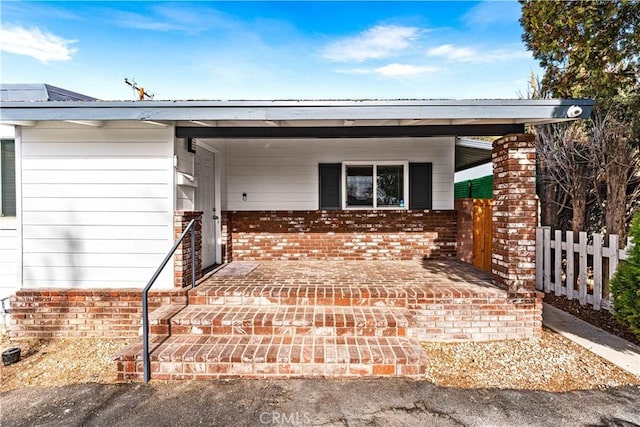 view of exterior entry with a carport