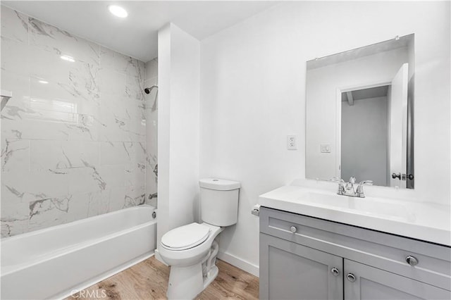 full bathroom featuring toilet, tiled shower / bath, wood-type flooring, and vanity