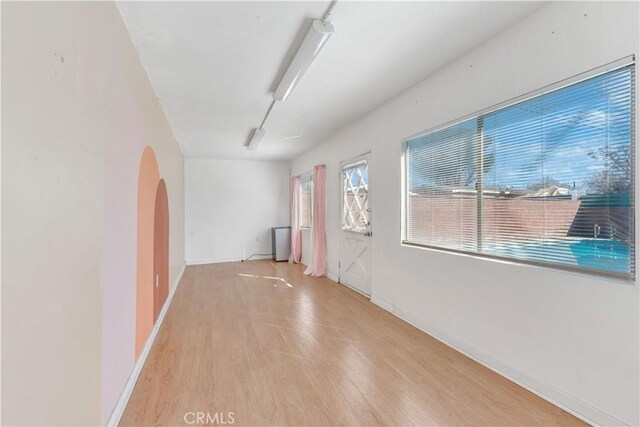 spare room with rail lighting and light hardwood / wood-style floors