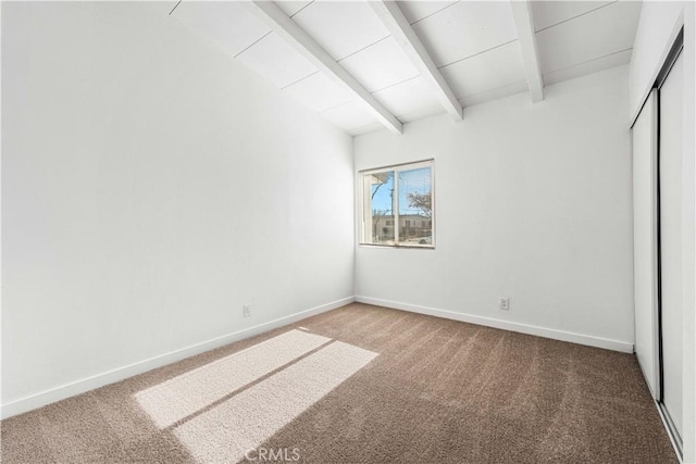 unfurnished bedroom featuring carpet flooring and lofted ceiling with beams