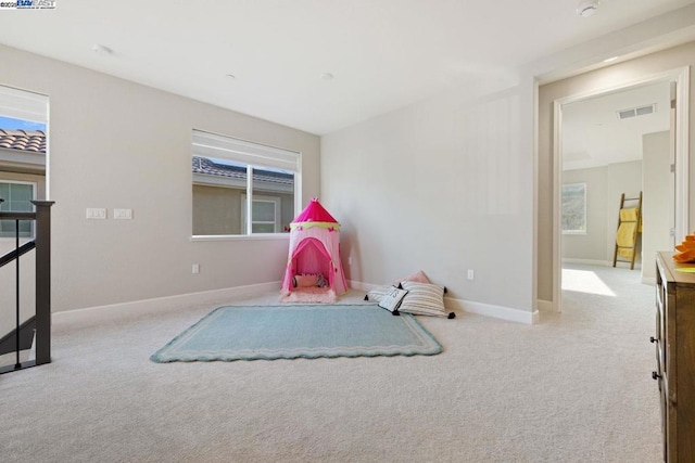 playroom featuring light colored carpet and plenty of natural light