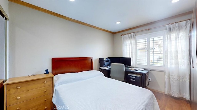 bedroom with ornamental molding and hardwood / wood-style flooring