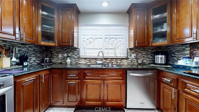 kitchen featuring decorative backsplash, dishwasher, dark stone counters, and sink