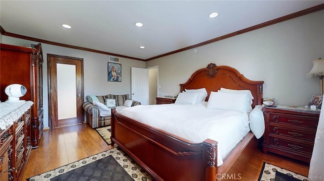 bedroom featuring ornamental molding and light hardwood / wood-style floors