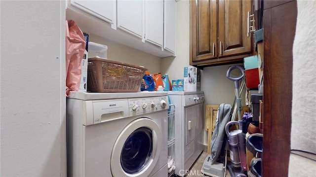 laundry room featuring cabinets and washing machine and clothes dryer