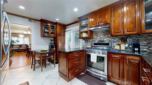 kitchen featuring appliances with stainless steel finishes, crown molding, tasteful backsplash, and dark stone counters