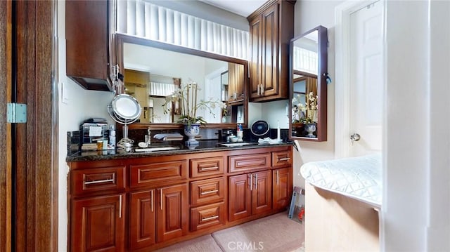 bar featuring sink, light tile patterned floors, and dark stone counters