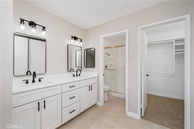 bathroom with tile patterned floors, an enclosed shower, vanity, and toilet