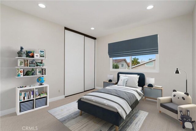 bedroom featuring light colored carpet and a closet