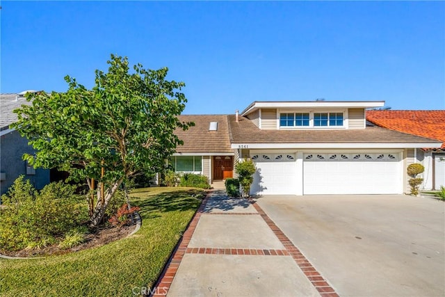 view of front of home with driveway, a garage, and a front yard