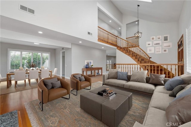 living area with stairway, visible vents, hardwood / wood-style flooring, and recessed lighting