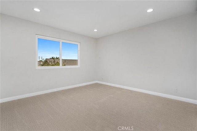 carpeted empty room featuring baseboards and recessed lighting