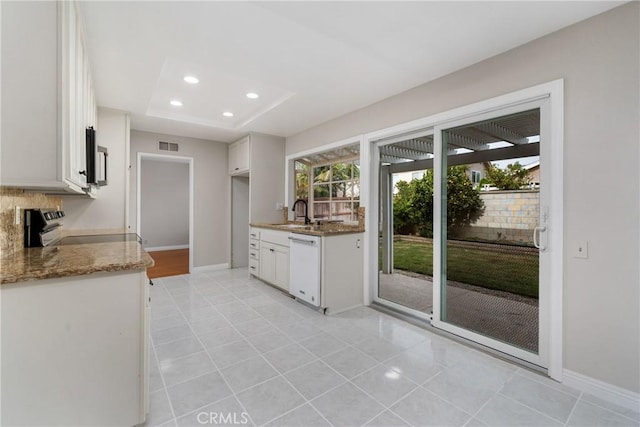 kitchen with stone counters, sink, white cabinetry, appliances with stainless steel finishes, and light tile patterned floors