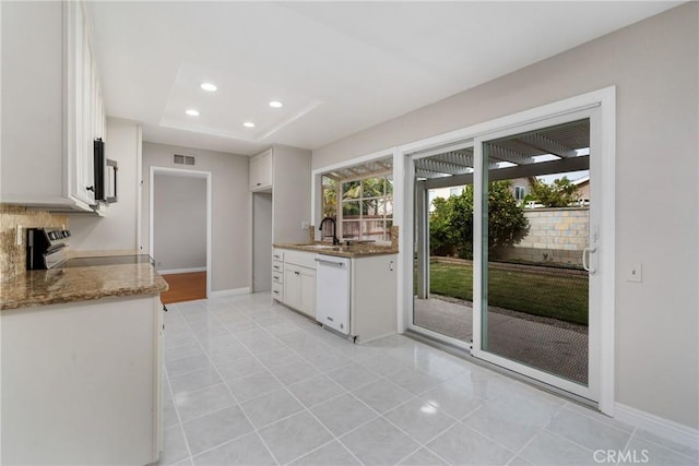 kitchen with light stone counters, recessed lighting, appliances with stainless steel finishes, white cabinetry, and a sink