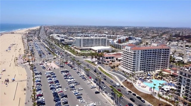 drone / aerial view featuring a view of the beach, a water view, and a city view