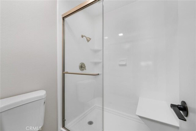 bathroom with toilet and walk in shower