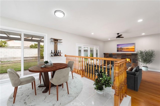 dining area with a fireplace, light wood finished floors, recessed lighting, ceiling fan, and baseboards