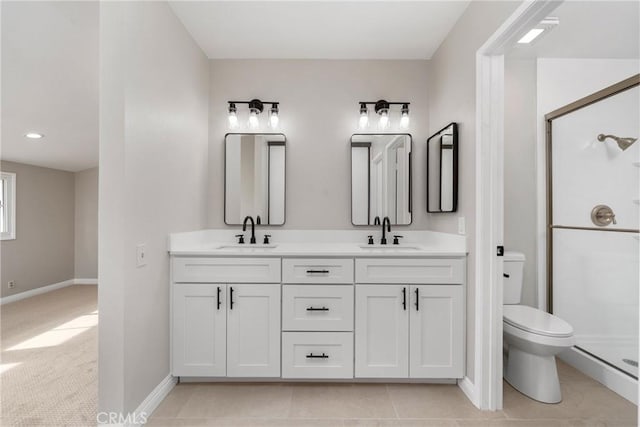 bathroom with a sink, a shower stall, toilet, and double vanity