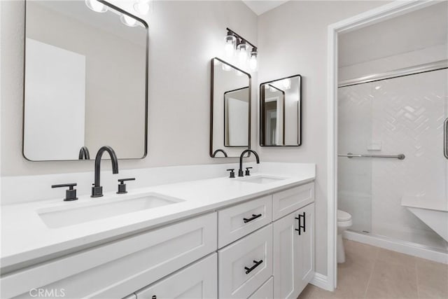 full bath featuring double vanity, a stall shower, a sink, and toilet