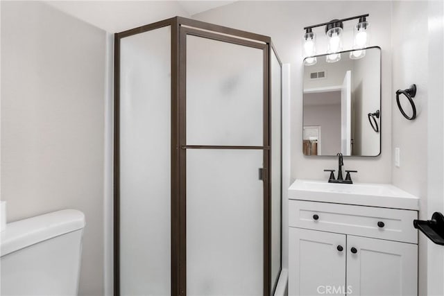 full bathroom with toilet, a stall shower, visible vents, and vanity