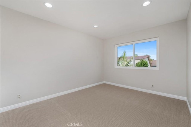 unfurnished room featuring recessed lighting, light colored carpet, and baseboards